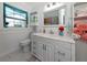 Bright bathroom featuring white cabinets, a white countertop, decorative mirror, and stylish tile flooring at 1722 Hazelwood St, Sarasota, FL 34231