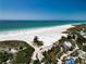 Aerial view of beach featuring pristine white sand, blue water, and lush vegetation at 1722 Hazelwood St, Sarasota, FL 34231