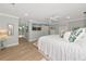 Spacious bedroom with white bedding, crown molding, an en-suite bathroom, and a mounted television at 1722 Hazelwood St, Sarasota, FL 34231