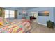 Bright bedroom featuring a colorful quilt, wood-look floors, and a glimpse into the living room at 1722 Hazelwood St, Sarasota, FL 34231
