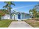 Charming light blue home with a striking blue door, manicured lawn, and inviting curb appeal at 1722 Hazelwood St, Sarasota, FL 34231