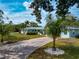 Inviting single-story home showcasing a long driveway, lush landscaping, and a serene, light blue exterior at 1722 Hazelwood St, Sarasota, FL 34231