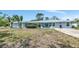 Single story blue home featuring large front yard and tropical landscaping at 1722 Hazelwood St, Sarasota, FL 34231