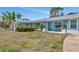 Charming blue home with tropical landscaping, inviting porch, and manicured front yard at 1722 Hazelwood St, Sarasota, FL 34231