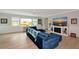 Cozy living room with a comfortable blue couch, fireplace, and natural light from the large windows at 1722 Hazelwood St, Sarasota, FL 34231