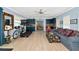 Spacious living room featuring wood-look floors, comfortable furniture, exercise equipment, and blue cabinets at 1722 Hazelwood St, Sarasota, FL 34231