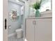 Cute powder room with stylish mirror, storage cabinet, and patterned floor tiles at 1722 Hazelwood St, Sarasota, FL 34231