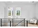 Hallway featuring black metal railings, light hardwood floors, with views into adjacent bedrooms and bright natural light at 2249 Oak Terrace St, Sarasota, FL 34231