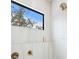 This shower features beautiful white tile, bronze fixtures and a window showcasing a scenic view at 2249 Oak Terrace St, Sarasota, FL 34231