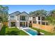 Back of house featuring pool, lawn, second-story balcony, and modern design at 2249 Oak Terrace Ter, Sarasota, FL 34231
