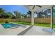 Relaxing backyard featuring a sparkling pool, a cozy covered patio, and lush green space for outdoor enjoyment at 2249 Oak Terrace Ter, Sarasota, FL 34231