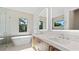 Bright bathroom featuring double sinks, soaking tub, shower, and a large window with tree view at 2249 Oak Terrace Ter, Sarasota, FL 34231
