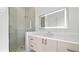Clean bathroom featuring walk-in shower, modern vanity, quartz countertop, and large, lighted mirror at 2249 Oak Terrace Ter, Sarasota, FL 34231