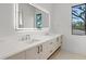 Bright bathroom featuring double sinks, modern vanity, quartz countertop, and large, lighted mirror at 2249 Oak Terrace Ter, Sarasota, FL 34231