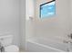 Clean bathroom featuring tub, shower, toilet, and white tile surround with a view from the window at 2249 Oak Terrace Ter, Sarasota, FL 34231