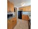 Galley kitchen features tile floors, wood cabinets and black appliances at 2321 Canal Dr # F25, Bradenton, FL 34207