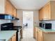 Functional kitchen with wood cabinets, black appliances, and tile backsplash at 2321 Canal Dr # F25, Bradenton, FL 34207