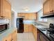 Functional kitchen with wood cabinets, black appliances, and tile backsplash at 2321 Canal Dr # F25, Bradenton, FL 34207