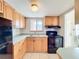 Functional kitchen with wood cabinets, black appliances, and tile backsplash at 2321 Canal Dr # F25, Bradenton, FL 34207