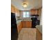 Galley kitchen features tile backsplash, wood cabinets and black appliances at 2321 Canal Dr # F25, Bradenton, FL 34207