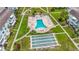Aerial view of a community pool with lounge chairs and tables, along with shuffleboard courts and walkways at 2321 Canal Dr # F25, Bradenton, FL 34207