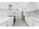 Open-concept kitchen with white cabinets, stainless appliances, and a spacious island with seating at 2408 Montpelier Rd, Punta Gorda, FL 33983