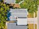 Aerial view of a home with a gray roof, surrounded by lush green trees and a driveway at 2435 Terry Ln, Sarasota, FL 34231