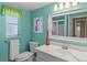 Bright bathroom with a large mirror, vanity, flamingo art, and calming turquoise walls at 2435 Terry Ln, Sarasota, FL 34231