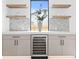 Stylish bar area featuring custom cabinets, a wine cooler, floating shelves, and decorative tile backsplash at 2554 Arlington St, Sarasota, FL 34239