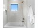 Relaxing bathroom with a soaking tub, sleek fixtures, and bright tile work with window for natural light at 2554 Arlington St, Sarasota, FL 34239