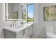 Elegant bathroom with double sinks, marble countertops, and a large window offering a scenic view at 2554 Arlington St, Sarasota, FL 34239