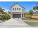 Modern two-story home featuring a neutral color scheme, a dark two-car garage door, and a well-manicured lawn at 2554 Arlington St, Sarasota, FL 34239