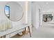 Bright foyer featuring white walls, a round mirror, a wood console table, and an open floor plan at 2554 Arlington St, Sarasota, FL 34239