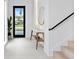 Bright foyer featuring white walls, a black banister, a round mirror, and stylish accents at 2554 Arlington St, Sarasota, FL 34239