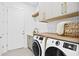 Well-lit laundry area with cabinets, open shelves, butcher block countertop, and modern washer/dryer units at 2554 Arlington St, Sarasota, FL 34239