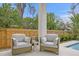 Charming outdoor patio with comfortable seating, accent table, and view of the pool and landscaping at 2554 Arlington St, Sarasota, FL 34239