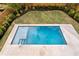 Aerial view of a modern backyard pool with a concrete deck and manicured landscaping at 2554 Arlington St, Sarasota, FL 34239