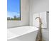 Elegant soaking tub with sleek fixtures, tile surround, and a sun-filled window at 2554 Arlington St, Sarasota, FL 34239