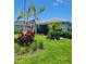 Beautiful backyard with lush landscaping, palm trees and a screened in patio at 26017 Seastone Dr, Englewood, FL 34223