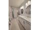 Bathroom with dual sinks, round mirrors, decorative wallpaper, and modern fixtures at 26017 Seastone Dr, Englewood, FL 34223