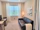 Bedroom or office featuring a couch, desk, carpeted floor, and bright natural light at 26017 Seastone Dr, Englewood, FL 34223