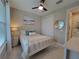 Cozy bedroom featuring a white metal bed frame, modern ceiling fan, and neutral decor at 26017 Seastone Dr, Englewood, FL 34223