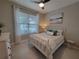 Bright bedroom featuring a white metal bed frame, view of a window, and soft decor at 26017 Seastone Dr, Englewood, FL 34223