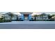 Community clubhouse featuring covered entrance, palm trees, and well-maintained landscaping at 26017 Seastone Dr, Englewood, FL 34223
