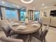Open dining room with stylish round table, seating for six, and view of both the living room and backyard at 26017 Seastone Dr, Englewood, FL 34223