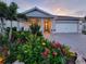 Beautiful single-story home featuring lush landscaping, a two-car garage, and a charming covered entryway at 26017 Seastone Dr, Englewood, FL 34223