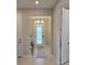 Bright foyer with a glass front door, chandelier, console table, and tile flooring at 26017 Seastone Dr, Englewood, FL 34223