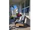 Cozy front porch with rocking chairs and decorative pillows next to a large window and blossoming flowers at 26017 Seastone Dr, Englewood, FL 34223