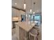 Bright kitchen boasts stainless appliances, white cabinets, and an island with bar seating and modern pendant lights at 26017 Seastone Dr, Englewood, FL 34223