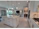 Open-concept kitchen features white cabinets, stainless appliances, and an island leading to the living room at 26017 Seastone Dr, Englewood, FL 34223
